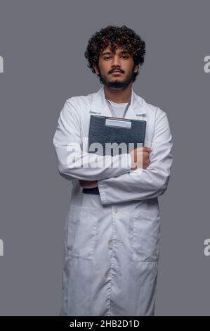 Junger Arzt mit medizinischen Dokumenten, die nach vorne schauen Stockfoto