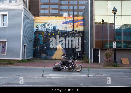 Ein Motorradfahrer fährt an einem Wandgemälde in Downtown Halifax, Nova Scotia, Kanada vorbei Stockfoto