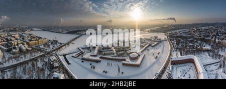 Drohne Sicht des Winters St. Petersburg bei Sonnenuntergang, gefrorener Neva Fluss, Dampf über der Stadt, Peter und Paul Festung, Autoverkehr auf Trinity Brücke Stockfoto