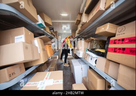 Ober Ramstadt, Deutschland. 15th Dez 2021. Ein DHL-Mitarbeiter sortiert Pakete und Pakete in seinem Van für die nächsten Lieferungen. (To dpa 'Deliverers carry out Millions of parcels before Christmas') Quelle: Sebastian Gollnow/dpa/Alamy Live News Stockfoto