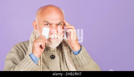 Älterer Mann mit Kopfschmerzen, der die Tempel berührt. Pillen von Kopfschmerzen oder Migräne. Notfallbehandlung. Speicherplatz kopieren. Stockfoto