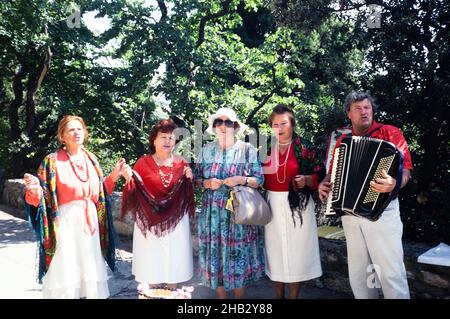 Folk Gruppe Akkordeon Musik außerhalb Jalta, Verbrechen, Russland in 1997 Frau Tourist posiert mit Künstlern Stockfoto