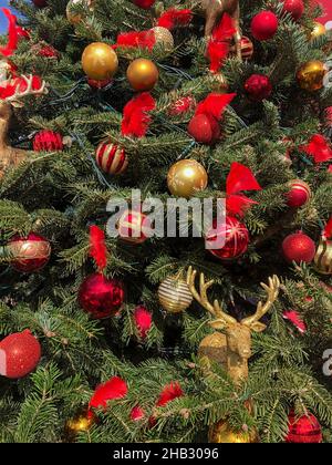 Noel Baum, geschmückter Weihnachtsbaum als Hintergrund für das neue Jahr. Weihnachtsbaum mit selektivem Fokus und Geräuscheffekten dekoriert rot und gelb ornam Stockfoto