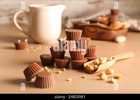 Leckere Schokoladen-Bonbons mit Erdnussbutter auf farbigem Hintergrund Stockfoto