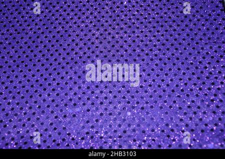 Glänzendes, violettes Material mit Punkten. Violette Polka-Dot-Qualität. Glänzendes Glitzermaterial. Lila Konfetti Mit Kleinen Punktmuster Und Pailletten. Stockfoto