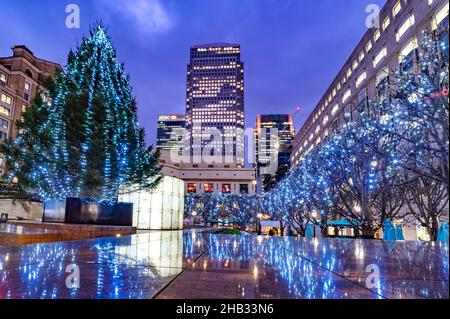 London, England, Großbritannien - 15. Dezember 2021: Weitblick auf den Cabot und den One Canada Square, beleuchtet in Abendlichtern, umgeben von Weihnachtsbaumdeko Stockfoto