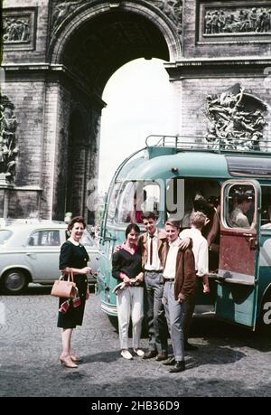 Drei junge Menschen zwei Männer eine Frau, die am offenen Eingang des Busses steht Ältere Frau in der Nähe, Arc de Triomphe, Paris, Frankreich c 1960 Stockfoto