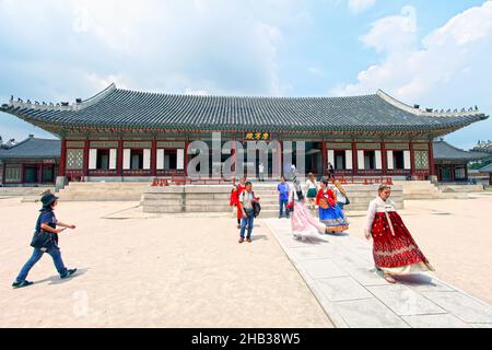 Besucher, die im Gyeongbokgung Palast in Seoul, Südkorea, in traditionelle Hanbok-Kostüme gekleidet sind. Stockfoto