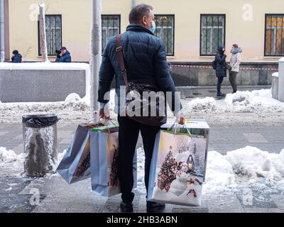 Moskau, Russland. 14th Dez 2021. Ein Mann mit Neujahrspaketen, der nach dem Einkaufen im zentralen Kindergeschäft in Lubyanka gesehen wurde Kredit: SOPA Images Limited/Alamy Live News Stockfoto