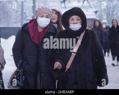 Moskau, Russland. 14th Dez 2021. Frauen mit Gesichtsmasken als vorbeugende Maßnahme gegen die Ausbreitung des Coronavirus gehen auf die Straße. (Foto: Alexander Sayganov/SOPA Images/Sipa USA) Quelle: SIPA USA/Alamy Live News Stockfoto