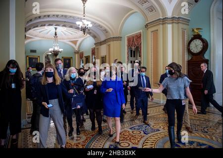 Washington, Vereinigte Staaten. 16th Dez 2021. Der US-Senator Mike Crapo (Republikaner von Idaho), rechts, kommt an der Ohio-Uhr vorbei, während die US-Senatorin Amy Klobuchar (Demokratin von Minnesota) von Reportern umgeben wird, als sie am Donnerstag, dem 16. Dezember 2021, bei einer Abstimmung im US-Kapitol in Washington, DC, in die Senatskammer eintrifft. Kredit: Rod Lampey/CNP/dpa/Alamy Live Nachrichten Stockfoto