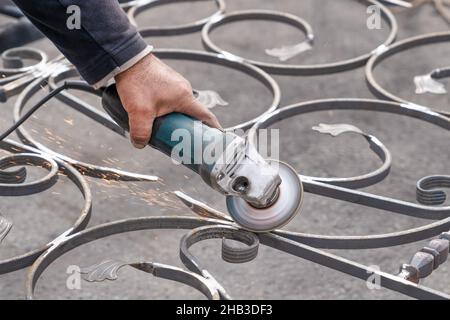 Metallschleifen mit Winkelschleifer. Männliche Hand und Instrument. Arbeiten mit Metall. Stockfoto