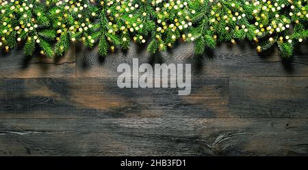 Weihnachtlicher Hintergrund mit goldenen Lichtern und Kiefernästen Stockfoto