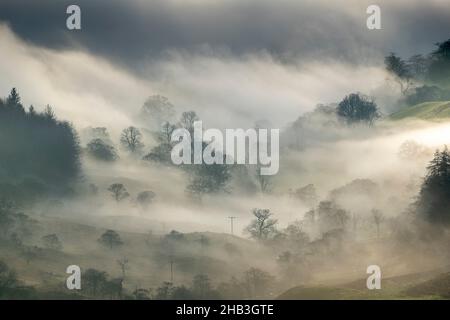 Kirkstone Pass, Cumbria, Großbritannien. 16th Dez 2021. Wetter. Stimmungsvolle Szenen vom fanmous Kirkstone Pass, der über Windermere blickt, während eine Wolkeninversion das Tal hinaufkriecht. Quelle: Wayne HUTCHINSON/Alamy Live News Stockfoto