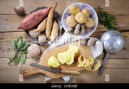 Verschiedene Kartoffeln auf altem Holzhintergrund, Draufsicht. Stockfoto