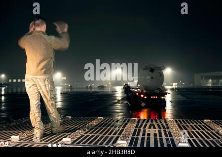 Senior Airman Bryce Mellish, 22nd Airlift Squadron Ladermaster, leitet einen K-Lader-Betreiber auf der Travis Air Force Base, Kalifornien, zu einer C-5M Super Galaxy am 16. Dezember 2021. Die Wasseraufbereitungssysteme sind für Red Hill, Hawaii, als Teil der US Transportation Command Red Hill Wasserbewegung bestimmt. Die Bewegung unterstützt die Gemeinsame Basis Pearl Harbor-Hickam Wasserqualitätsgewinnung, eine gemeinsame US-militärische Initiative, die eng mit dem Bundesstaat Hawaii, dem Gesundheitsministerium, dem Honolulu Board of Water Supply, der US-Regierung und unabhängigen Organisationen zusammenarbeitet, um ein sicheres Wasserversorgungssystem für JB wiederherzustellen Stockfoto