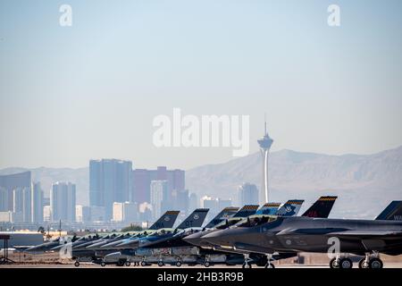 Sieben F-16 Fighting Falcons und zwei F-35A Lightning IIS stehen am Ende der Start- und Landebahn an, während sie sich auf die Teilnahme an der Integrationsübung der US-Luftwaffenschule am Nellis Air Force Base, Nevada, am 8. Dezember 2021 vorbereiten. Die USAF Weapons School unterrichtet Lehrgänge auf Graduiertenniveau und bietet Offiziere und beauftragte Spezialisten für Kampf- und Mobilitätsluftstreitkräfte erweiterte Schulungen in Waffen- und Taktikeinsatz an. (USA Luftwaffe Foto von Michael J. Hasenauer) Stockfoto