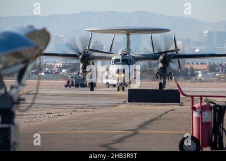 Ein Flugzeug der US Navy E-2C Hawkeye, das dem Naval Aviation Warfighting Development Center auf der Naval Air Station Fallon, Nevada, zugewiesen wurde, nimmt an einer Übung zur Integration der US-Luftwaffenschule am Nellis Air Force Base, Nevada, am 8. Dezember 2021 Teil. Die E-2C ist das wetterabhängige, trägergestützte taktische Kampfmanagement der Marine, das Frühwarn-, Befehls- und Kontrollflugzeug in der Luft ist. (USA Luftwaffe Foto von Michael J. Hasenauer) Stockfoto