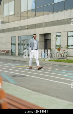 Urban Businessman läuft vor dem Unternehmen, während er über die Pläne nachdenkt Stockfoto