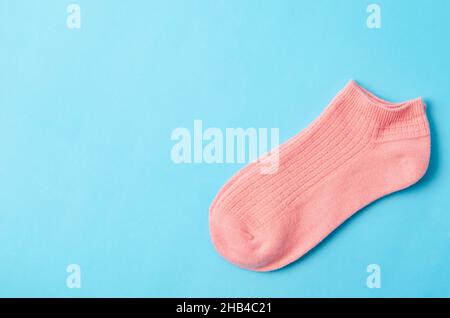 Rosa Socken auf blauem Hintergrund und Platz für Text. Stockfoto