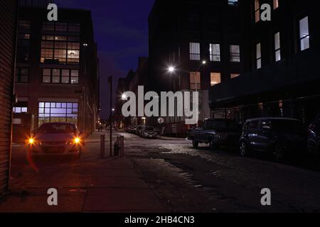 Blick auf den Fluchtpunkt der Nacht in der Water Street in DUMBO, Brooklyn, Langzeitbelichtung im Retro-Look. Stockfoto