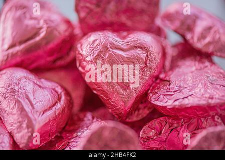Herzförmige Schokoladen-Bonbons in rosa Aluminiumfolie an der Dessertbar eingewickelt Stockfoto