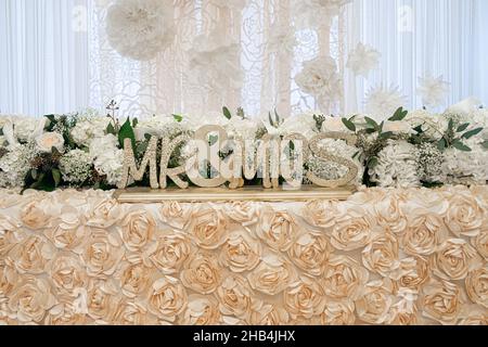 Goldenes Mr.&Mrs. Holzschild auf dem wunderschönen Liebsten-Tisch beim Hochzeitsempfang Stockfoto