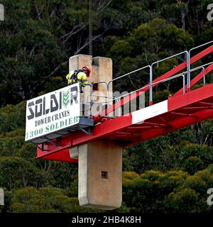 9:58 Uhr 7. Dezember 2021: Gosford, NSW, Australien. Arbeiter demontieren den Turmdrehkran vor Ort (Entfernen der Gegengewichte) auf dem fertig gestellten sozialen Netzwerk Stockfoto