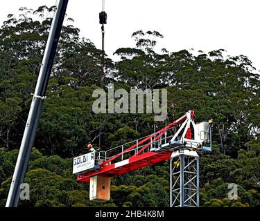 9:57 Uhr 7. Dezember 2021: Gosford, NSW, Australien. Arbeiter demontieren den Turmdrehkran vor Ort (Entfernen der Gegengewichte) auf dem fertig gestellten sozialen Netzwerk Stockfoto