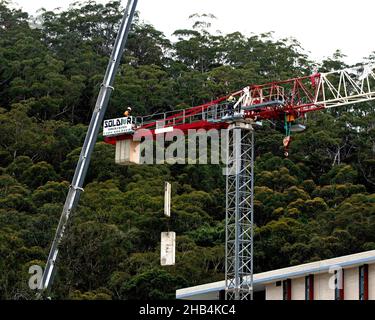 8:05 Uhr 7. Dezember 2021: Gosford, NSW, Australien. Arbeiter demontieren den Turmdrehkran vor Ort (Entfernen der Gegengewichte) auf dem fertig gestellten sozialen Netzwerk Stockfoto