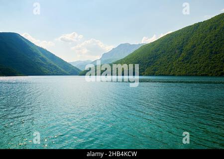 Ruhiger türkisfarbener See zwischen Berggipfeln in Montenegro. Ruhige Naturlandschaft Stockfoto