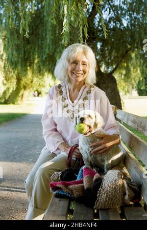 Ältere Frau mit ihrem älteren Cockapoo-Hund Stockfoto