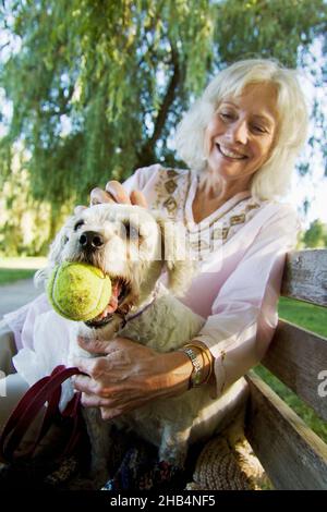 Ältere Frau mit ihrem älteren Cockapoo-Hund Stockfoto