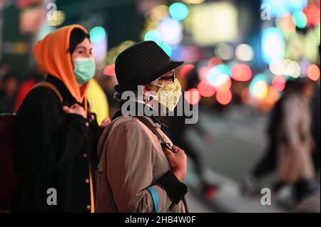 New York, USA. 16th Dez 2021. Menschen, die durch den Times Square laufen, tragen Masken, da Berichte über die Verdopplung der COVID-19-Positivitätsraten in New York City durch die Omicron-Variante, New York, NY, 16. Dezember 2021, veröffentlicht wurden. New York City hat bis zum 15. Januar 2022 ein neues Maskenmandat sowohl für den Innen- als auch den Außeneinsatz erteilt. (Foto von Anthony Behar/Sipa USA) Quelle: SIPA USA/Alamy Live News Stockfoto