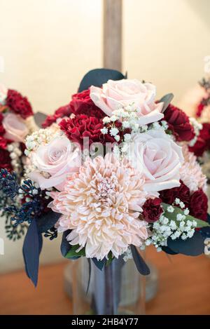 Rote, rosa und weiße Brautsträuße in Glasvasen Stockfoto