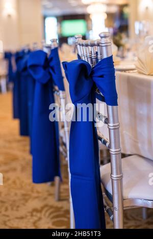 Sliver chiavari-Stühle mit blauen Schleifen und Bändern bei Hochzeitsempfängen Stockfoto