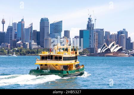 Die Fähre von Sydney fährt mit der MV Fishburn in Richtung Circular Quay mit der Skyline von Sydney und dem Opernhaus von Sydney in der Ferne, Sydney Harbour, NSW Stockfoto