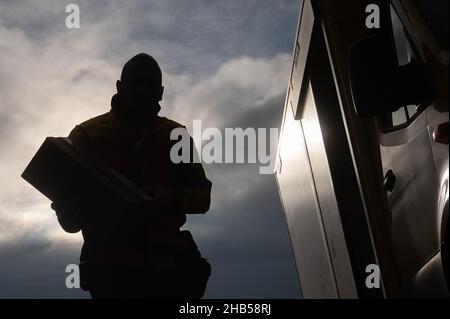 Ober Ramstadt, Deutschland. 15th Dez 2021. Ein DHL-Mitarbeiter liefert ein Paket aus. Quelle: Sebastian Gollnow/dpa/Alamy Live News Stockfoto