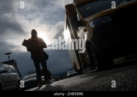 Ober Ramstadt, Deutschland. 15th Dez 2021. Ein DHL-Mitarbeiter liefert ein Paket aus. Quelle: Sebastian Gollnow/dpa/Alamy Live News Stockfoto