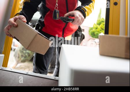 Ober Ramstadt, Deutschland. 15th Dez 2021. Ein DHL-Mitarbeiter scannt ein Paket zur Lieferung. Quelle: Sebastian Gollnow/dpa/Alamy Live News Stockfoto