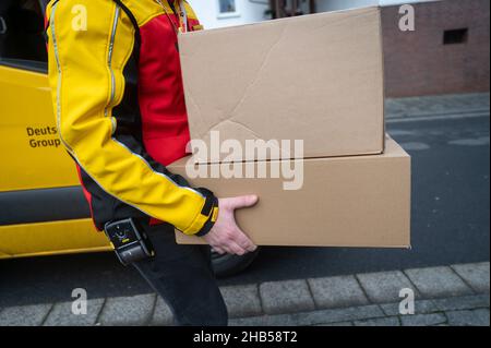 Ober Ramstadt, Deutschland. 15th Dez 2021. Ein DHL-Mitarbeiter liefert ein Paket aus. Quelle: Sebastian Gollnow/dpa/Alamy Live News Stockfoto