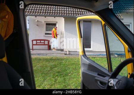 Ober Ramstadt, Deutschland. 15th Dez 2021. Ein DHL-Mitarbeiter liefert ein Paket aus. Quelle: Sebastian Gollnow/dpa/Alamy Live News Stockfoto