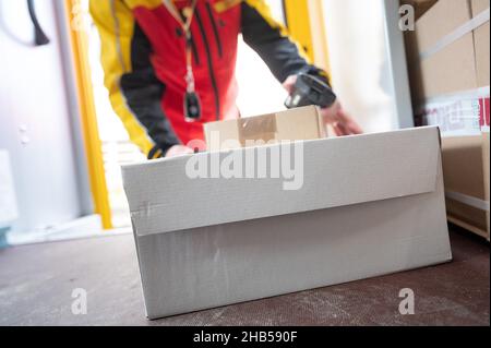 Ober Ramstadt, Deutschland. 15th Dez 2021. Ein DHL-Mitarbeiter nimmt ein Paket aus seinem Van. Quelle: Sebastian Gollnow/dpa/Alamy Live News Stockfoto