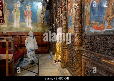 Eine äthiopisch-orthodoxe Christin betet vor der Ikonostase in der griechisch-orthodoxen Kirche der Verkündigung, auch bekannt als die Kirche des heiligen Gabriel oder die griechisch-orthodoxe Kirche des heiligen Gabriel in der Stadt Nazareth, Nordisraelien Stockfoto