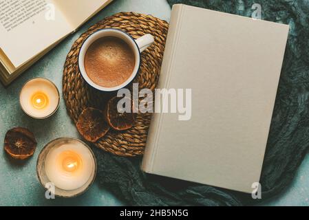 Draufsicht auf Bücher und eine Tasse Kaffee mit Kerzen auf einem Tisch. Selektiver Fokus Stockfoto