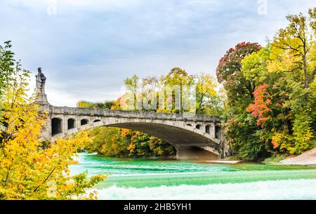 Türkisfarbene Isar und Herbstlandschaft der maximilian-Brücke in München Stockfoto