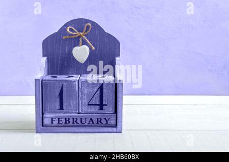 Ewiger Holzkalender auf Datum Februar 14. Valentinstag. Farbe des Jahres 2022 sehr peri. Postkarte. Kopieren Sie Speicherplatz für Ihre besseren Projekte. Stockfoto