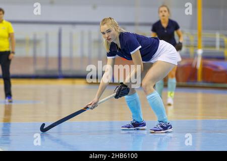 Junge Hockeyspielerin spielt Hallenhockey Stockfoto