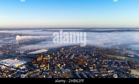 Bradford, West Yorkshire, Großbritannien. Dezember 2021. Wolkenumkehr über der Stadt an einem kühlen Wintermorgen mit Blick nach Nordosten. Eine Schicht aus niedriger Wolke und Nebel bedeckt einen Großteil des städtischen Gebiets, während höhere Strukturen und höhere Böden über der Inversion sichtbar bleiben. Das Foto wurde aus einer erhöhten Position bei klaren Bedingungen über der Nebelschicht aufgenommen. Typisches Wintertemperaturumkehrungsereignis, das in dieser nordenglischen Stadt aufgezeichnet wurde. Keine Personen oder bestimmte Sehenswürdigkeiten stehen im Mittelpunkt; das Bild zeigt den meteorologischen Effekt in der gesamten bebauten Umgebung. Stockfoto