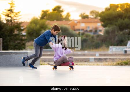 Zwei Freunde spielen mit einem Skateboard Stockfoto